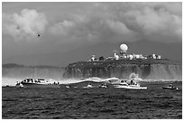 Flottila of boats near Mavericks break in front of Pillar Point radar station. Half Moon Bay, California, USA ( black and white)