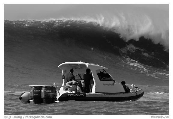 Small boat dwarfed by huge wave. Half Moon Bay, California, USA (black and white)