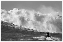 Jet ski dwarfed by huge breaking wave. Half Moon Bay, California, USA (black and white)
