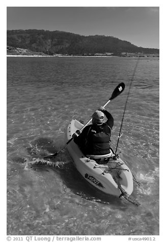 Sea kayaker with fishing rod in Carmel Bay. Carmel-by-the-Sea, California, USA (black and white)