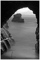 Ocean seen from sea arch at sunset, Davenport. California, USA ( black and white)