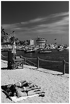 Women sunning on beach near harbor, Avalon, Catalina. California, USA ( black and white)