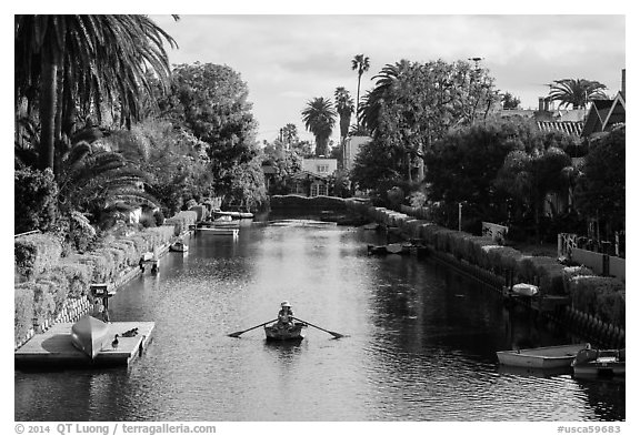 Woman rowing in canal. Venice, Los Angeles, California, USA (black and white)