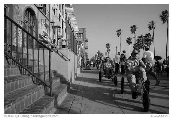 Men riding tricycles on Ocean Front Walk. Venice, Los Angeles, California, USA (black and white)
