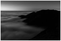 Hills emerging from sea of clouds at dusk, Garrapata State Park. Big Sur, California, USA ( black and white)