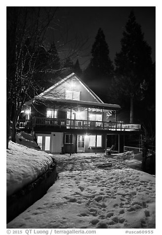 Cabin with window lights in winter. California, USA (black and white)
