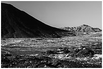 Lava field, Amboy Crater slope and mountains. Mojave Trails National Monument, California, USA ( black and white)