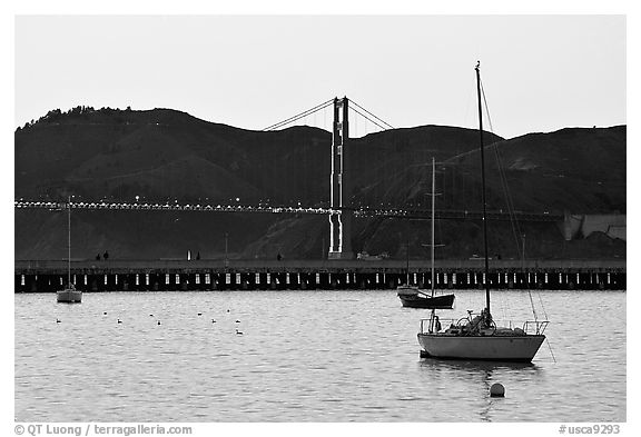 Sailboat in the Marina, with Golden Gate Bridge at sunset in the background. San Francisco, California, USA (black and white)