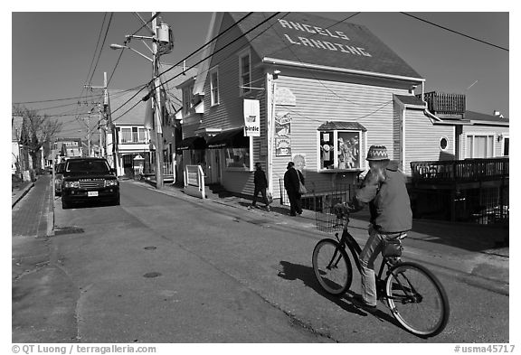 Woman biking on main street, Provincetown. Cape Cod, Massachussets, USA