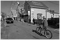 Woman biking on main street, Provincetown. Cape Cod, Massachussets, USA (black and white)