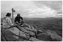 Hikers taking in view near sign marking summit of South Turner Mountain. Baxter State Park, Maine, USA (black and white)