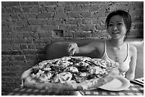 Woman getting slice of pizza at Lombardi. NYC, New York, USA (black and white)