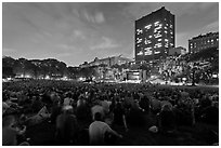 Crowd sitting on lawn during evening outdoor concert, Central Park. NYC, New York, USA ( black and white)