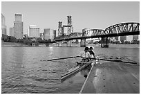 Rowers on double-oar shell lauching from deck in front of skyline. Portland, Oregon, USA ( black and white)