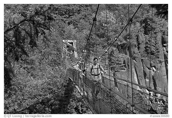 Hikers cross suspension bridge over Lava Canyon. Mount St Helens National Volcanic Monument, Washington (black and white)