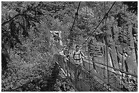 Hikers cross suspension bridge over Lava Canyon. Mount St Helens National Volcanic Monument, Washington (black and white)