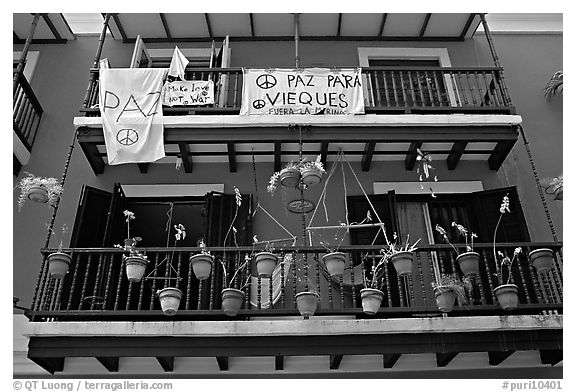 Facade of house painted in blue with pots, balconies and anti-war signs. San Juan, Puerto Rico (black and white)