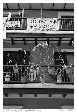 Facade of house painted in blue with plant pots and balconies. San Juan, Puerto Rico (black and white)