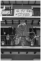 Facade of house painted in blue with plant pots and balconies. San Juan, Puerto Rico ( black and white)