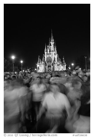 Crowds walking away from Cinderella Castle at night. Orlando, Florida, USA