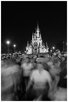 Crowds walking away from Cinderella Castle at night. Orlando, Florida, USA ( black and white)