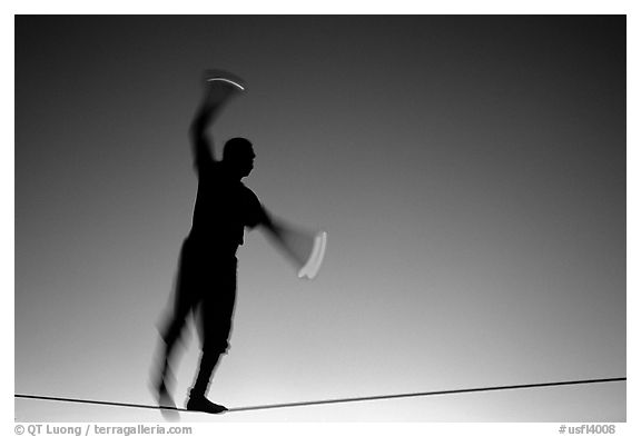 Equilibrist on Mallory Square, sunset. Key West, Florida, USA (black and white)