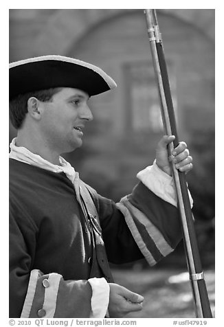 Man dressed as a Spanish soldier in the 18th century demonstrates gun, Fort Matanzas National Monument. St Augustine, Florida, USA (black and white)