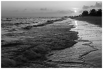 Beach with people in the distance at sunset, Sanibel Island. Florida, USA (black and white)