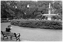 Forsyth Park Fountain with woman sitting on bench with book. Savannah, Georgia, USA ( black and white)