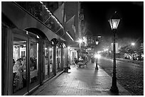 Restaurant, lamps, and sidewalk of River Street by night. Savannah, Georgia, USA ( black and white)
