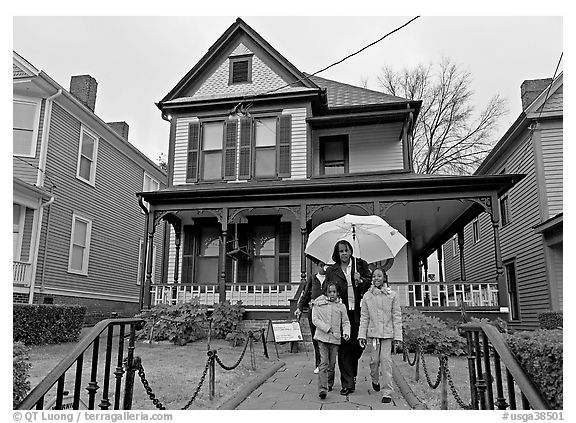 African American family with umbrella in front of Birth Home of Martin Luther King Jr. Atlanta, Georgia, USA (black and white)