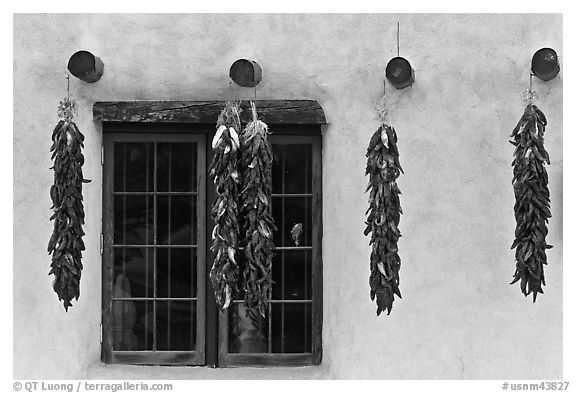 Yellow wall with ristras and blue window. Taos, New Mexico, USA (black and white)