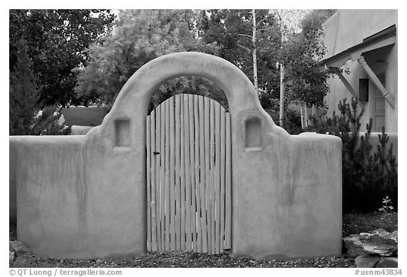 Blue door and adobe yard wall. Taos, New Mexico, USA (black and white)