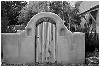 Blue door and adobe yard wall. Taos, New Mexico, USA (black and white)