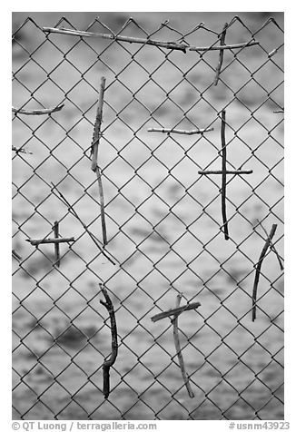 Crosses made of twigs on chain-link fence, Sanctuario de Chimayo. New Mexico, USA (black and white)