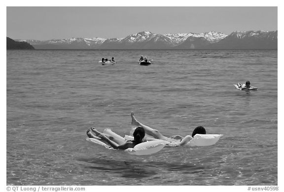 Children playing in water, and distant snowy mountains, Sand Harbor, Lake Tahoe, Nevada. USA (black and white)