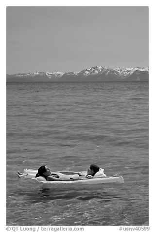 Girls laying on floating mattress, Sand Harbor, East Shore, Lake Tahoe, Nevada. USA (black and white)