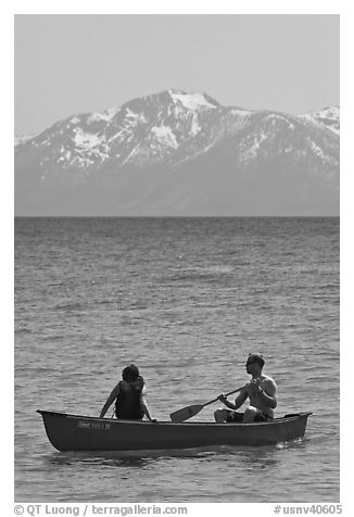 Man and woman in canoe with snowy mountains in the background, Lake Tahoe, Nevada. USA (black and white)