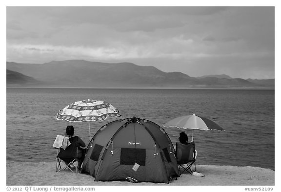 People with tent and beach umbrellas, approaching storm. Pyramid Lake, Nevada, USA