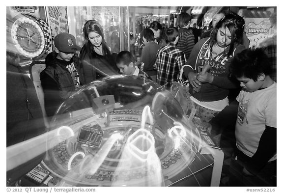Family plays arcade game with spining lights. Reno, Nevada, USA