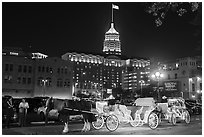 Horse carriages and Tower Life Building at night. San Antonio, Texas, USA ( black and white)