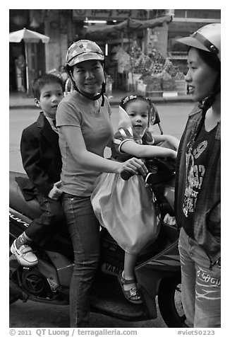 Woman riding with children. Ho Chi Minh City, Vietnam