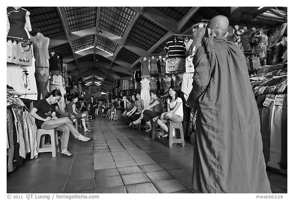 Buddhist Monk walking into Ben Thanh Market. Ho Chi Minh City, Vietnam (black and white)