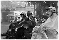 Motorcycle riders during afternoon mooson. Ho Chi Minh City, Vietnam (black and white)