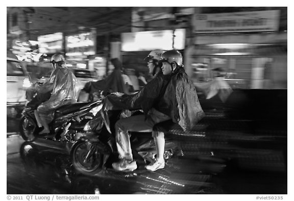 Motorcyle riders at night, dressed for the rain. Ho Chi Minh City, Vietnam (black and white)