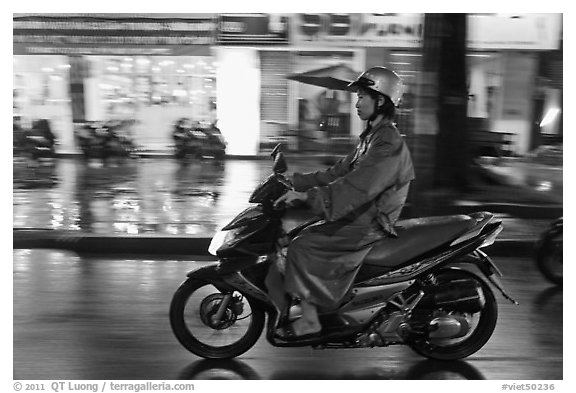 Riding motorcyle on rainy night. Ho Chi Minh City, Vietnam (black and white)