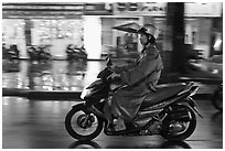 Riding motorcyle on rainy night. Ho Chi Minh City, Vietnam (black and white)
