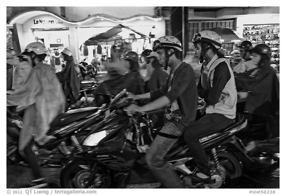 Street crowded with motorcycles on rainy night. Ho Chi Minh City, Vietnam