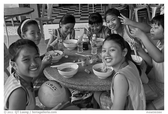 Girls sports team eating, Van Hoa Park. Ho Chi Minh City, Vietnam (black and white)