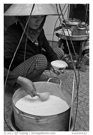 Woman serving a bowl of soft tofu. Ho Chi Minh City, Vietnam (black and white)